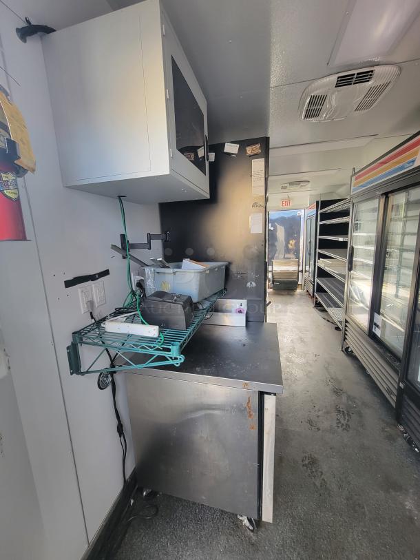 2021 SDG 20' mobile kitchen trailer interior, featuring stainless steel work surfaces, shelving, and overhead storage.