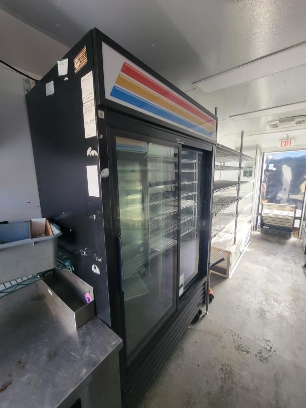 Mobile ghost kitchen trailer interior with commercial fridge, shelving, and stainless steel countertop. Model: SDG 20; built 2021.