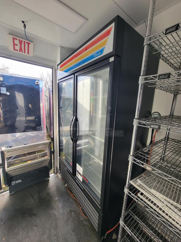 2021 SDG 20' Mobile Ghost Kitchen Trailer featuring dual-axle design, glass-door fridge, wire shelving, and Reef/Lightspeed setup.
