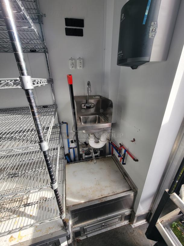 2021 20' SDG Mobile Ghost Kitchen trailer interior with stainless sink, shelving, and commercial equipment setup.