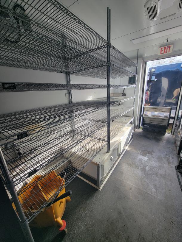 2021 SDG 20' Mobile Ghost Kitchen Trailer, dual-axle, metal shelving, exit sign. Ideal for order fulfillment. Used condition.