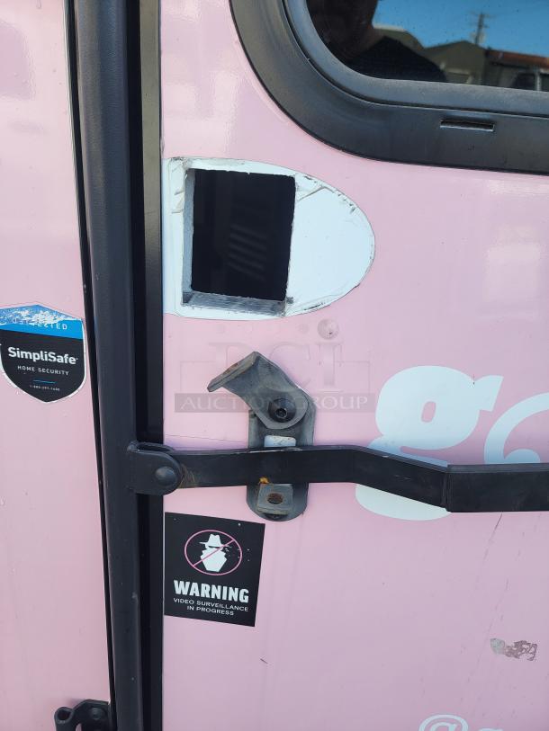 2021 SDG Ghost 20' food trailer door with missing handle, SimpliSafe security sticker, and warning sign for video surveillance.