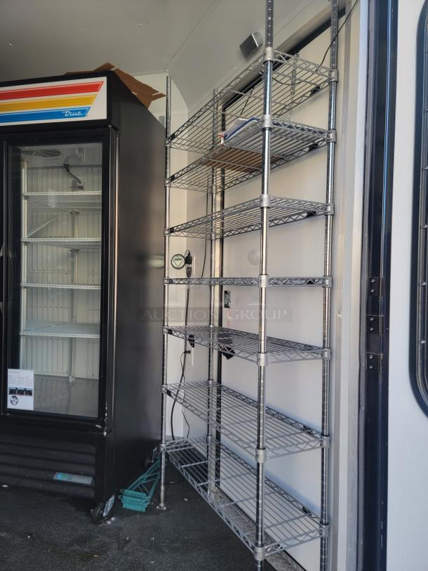 2021 SDG Ghost 20' food trailer interior with True commercial refrigerator and metal shelving units.