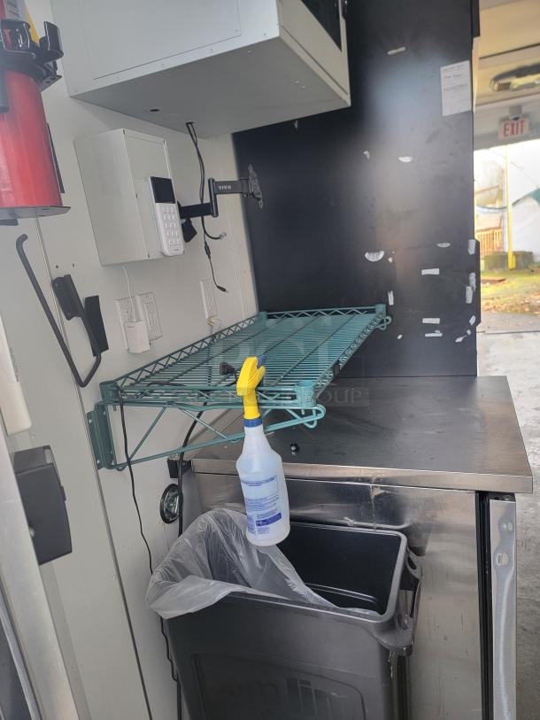 2021 SDG Ghost 20' food trailer interior, stainless steel workspace, modern shelving, fire extinguisher, surveillance system.