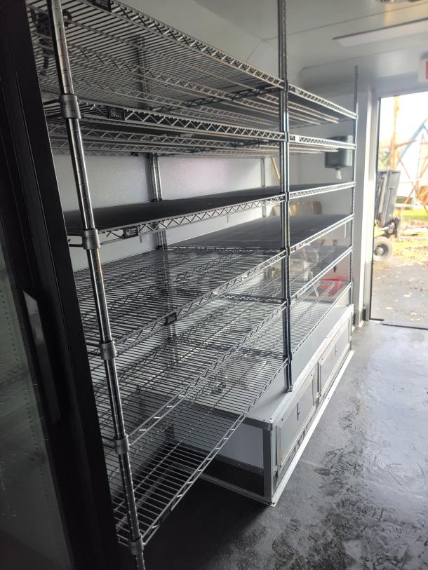 2021 SDG Ghost Food Trailer interior with stainless steel wire shelving and built-in storage, ready for operation.