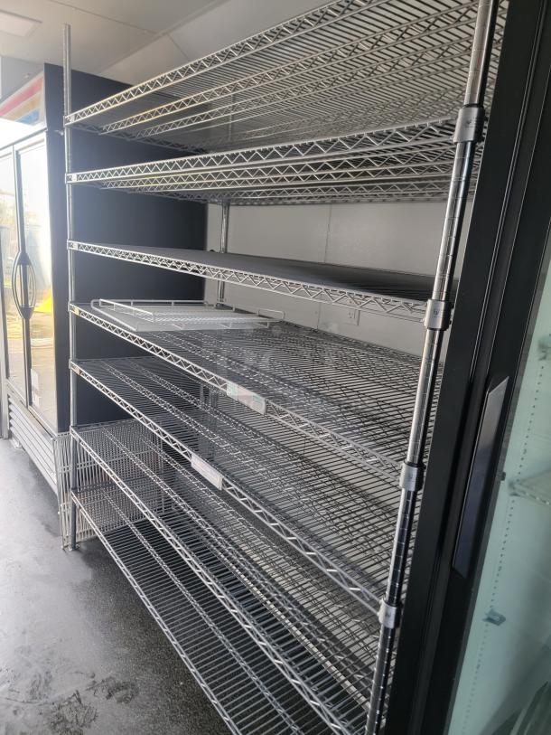 2021 SDG Ghost 20' food trailer interior showing multiple empty stainless steel shelving units for storage.