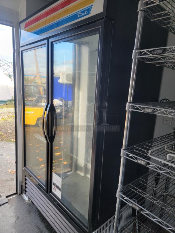 20' SDG Ghost Food Trailer interior with True commercial refrigerator and metal shelving, clean condition, ready for use.