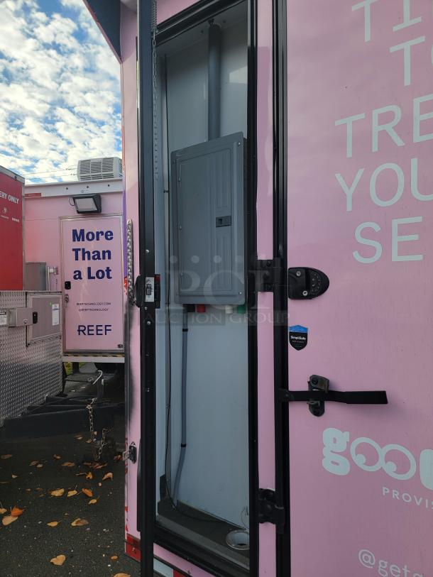 20' 2021 SDG Ghost Food Trailer, pink exterior, visible electrical panel, partially open door, "More Than a Lot" marking.