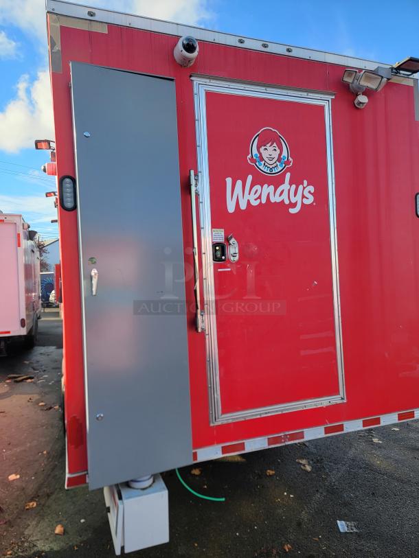 Red 2021 28' Rock Solid Cargo mobile kitchen trailer with Wendy's branding, security camera, and commercial equipment setup.