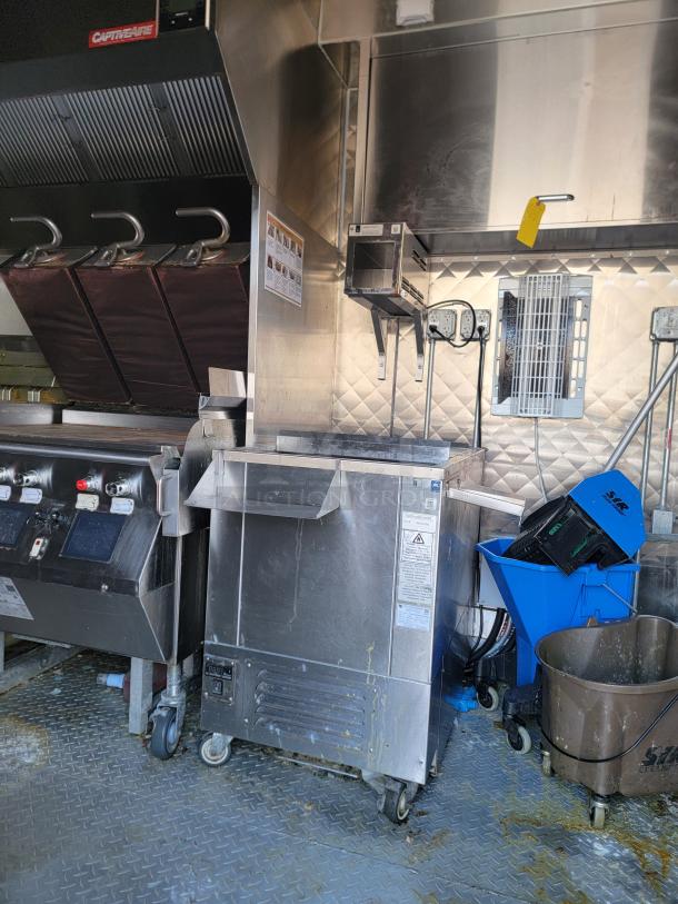 28' Rock Solid Cargo mobile kitchen trailer interior with commercial appliances, vents, and plumbing. Features CaptiveAire hood and fryer.