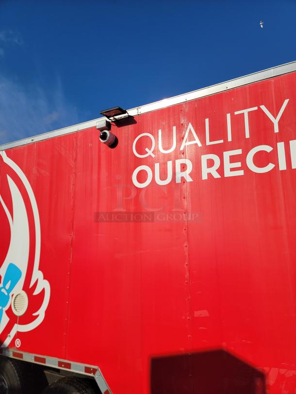 28' Rock Solid Cargo mobile kitchen trailer, red with "Quality Our Recipe" signage, external surveillance camera visible.