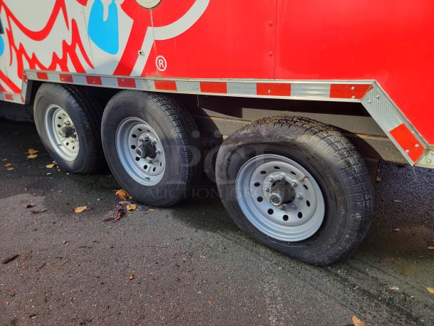 2021 Rock Solid Cargo 28' Mobile Kitchen Trailer with triple axle wheels, red exterior, ready for high-volume food service.