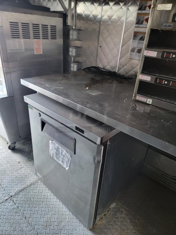 2021 28' Rock Solid Cargo mobile kitchen trailer interior with stainless steel counters, commercial fridge, and equipment.
