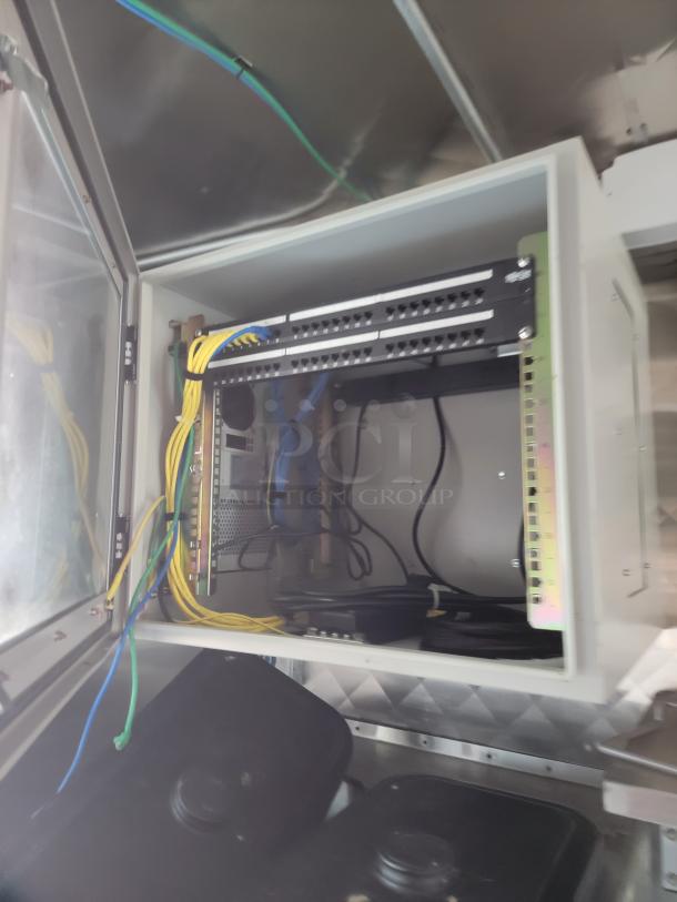 Electrical compartment in a 2021 Rock Solid Cargo 28' mobile kitchen trailer, showing wiring and network equipment.