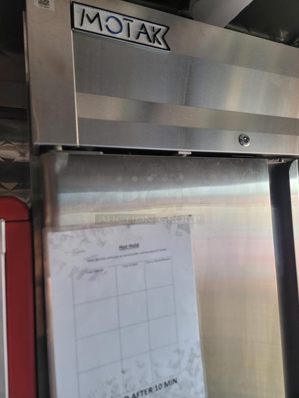 Motak commercial refrigerator in a 2021 Rock Solid Cargo 28' mobile kitchen trailer, with checklist seen on the door.