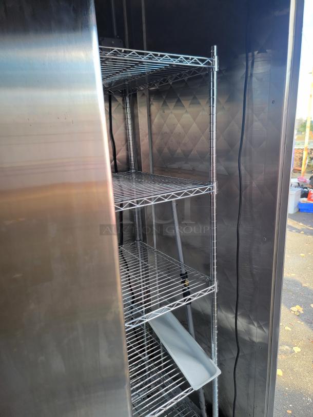 Interior view of a Rock Solid Cargo 28' mobile kitchen trailer showing stainless steel shelving and stainless walls.