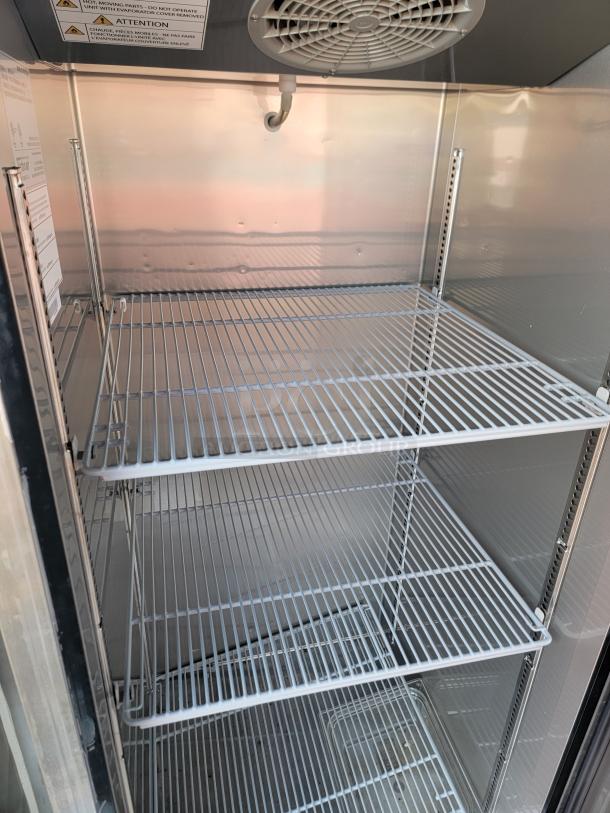 Interior of a 2021 Rock Solid Cargo 28' Mobile Kitchen Trailer; features wire shelving and cooling fan, ideal for food storage.