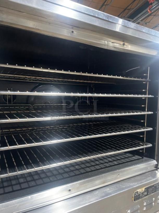 Blodgett stainless steel double convection oven, electric powered, with wired racks and thermostatic control; on legs, visible branding.