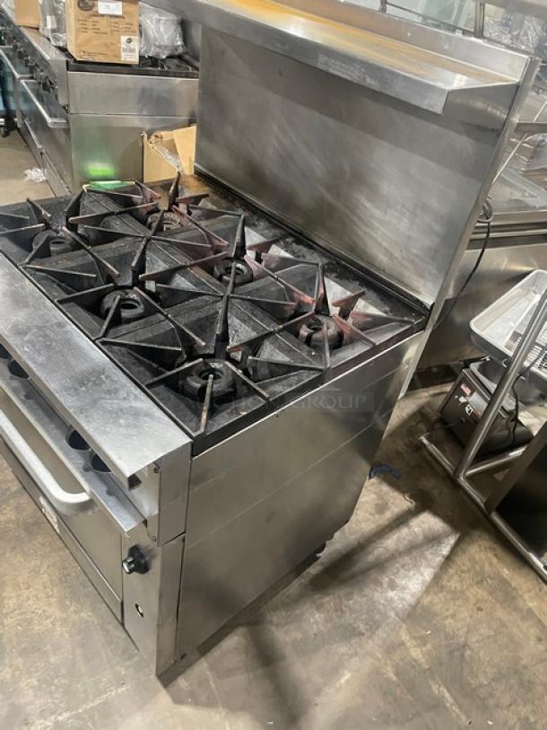 Vulcan 36SF-6BN commercial stainless steel stove with 6 burners, convection oven, backsplash, and salamander shelf. On casters.
