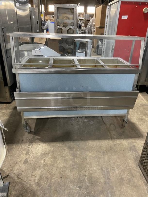 Atlas Metal 4-well stainless steel steamtable with sneeze guard, folding tray slide, and casters. Model WIH-D&M-4, 208V, 1-phase.