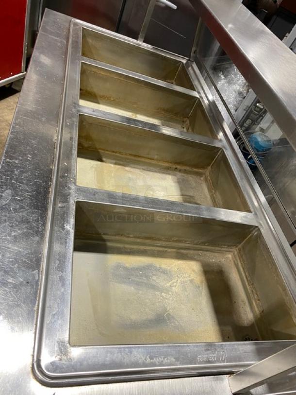 Atlas Metal 4-well stainless steel hot food steamtable, model WIHD&M4. Features serve-over sneeze guard, folding tray slide, on casters.