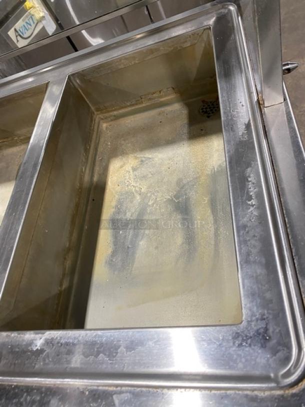 Atlas Metal four-well stainless steel steamtable with sneeze guard, model WIHD&M4, on casters, showing interior wear.