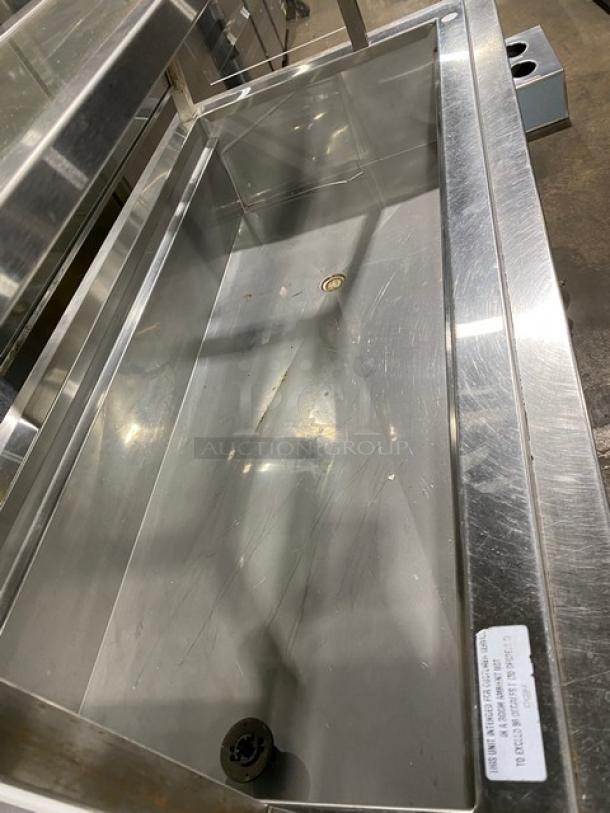 Delfield N8156B stainless steel refrigerated salad bar with sneeze guard, tray slide, and undershelf on casters. Visible scuffs.