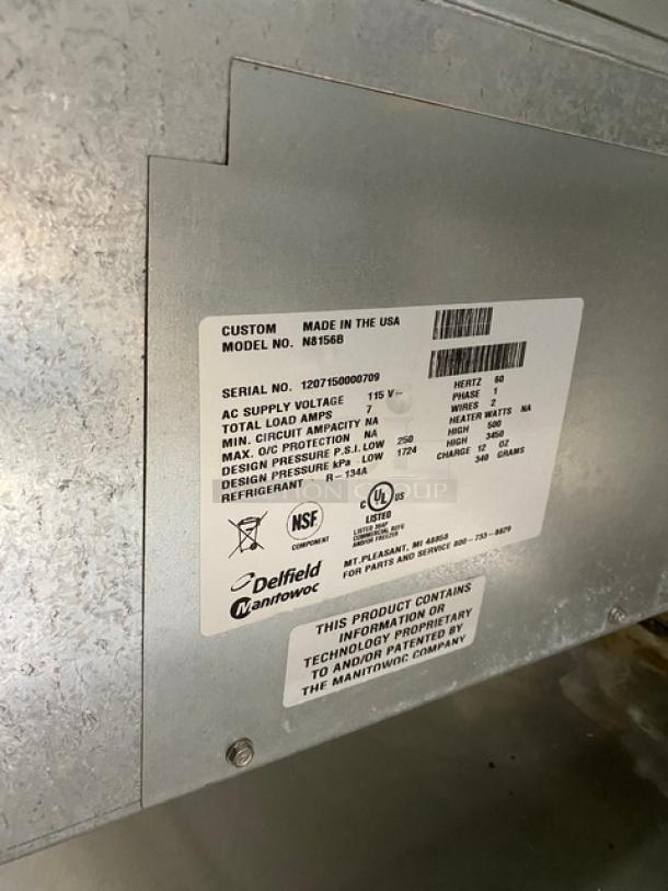 Delfield Model N8156B stainless steel refrigerated salad bar, serial 1207150000709, 115V, with sneeze guard, tray slide, and undershelf.