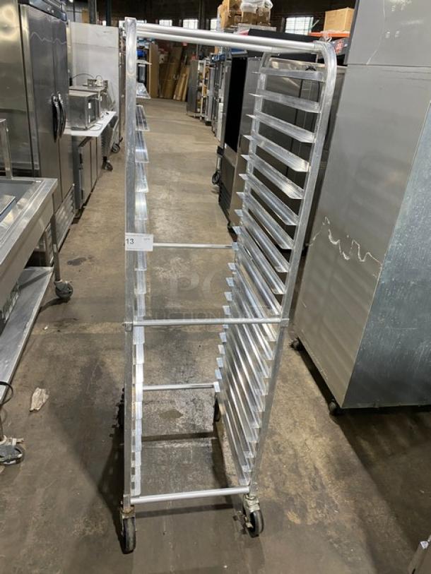 Commercial stainless steel pan holding/transport rack with casters, multiple slots, used condition, tag labeled "13".