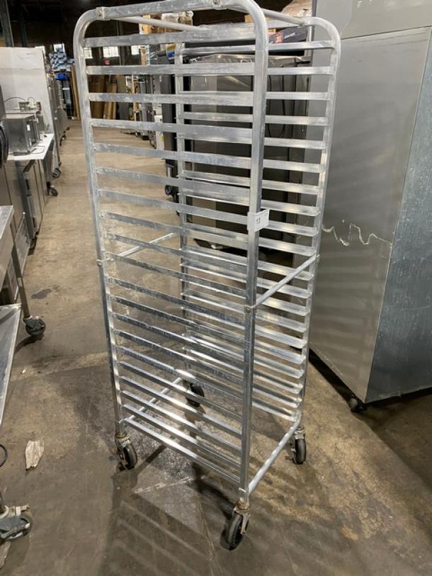 Commercial stainless steel pan holding/transport rack on casters; multiple shelves; used condition; ideal for kitchen use.