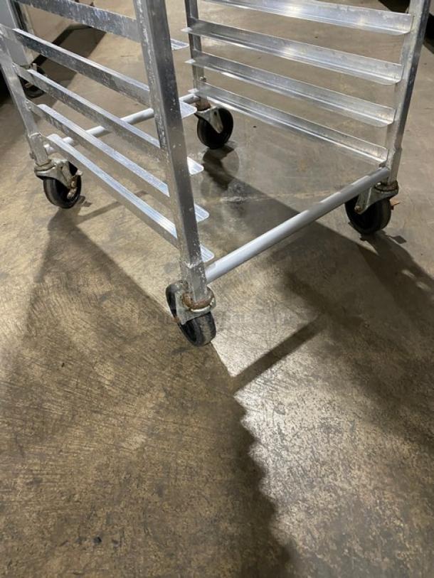 Commercial stainless steel pan transport rack on casters, features multiple shelves. Used condition, ideal for kitchen use.