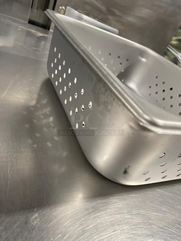 Stainless steel half-size, 4" deep, perforated steamtable pan, model 2220243. New condition, ideal for commercial use.