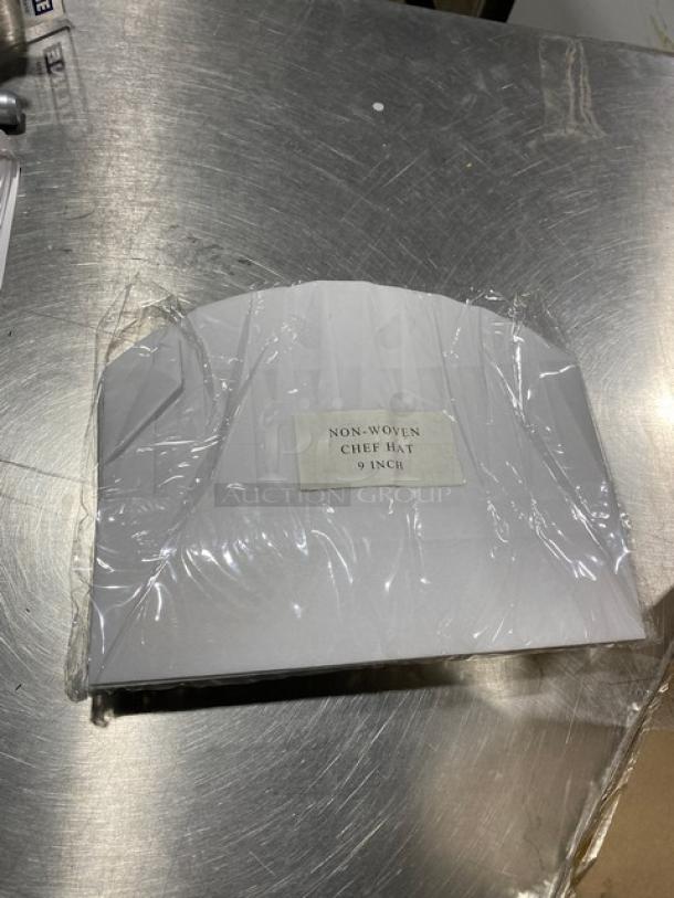 New Landau Uniforms 9" round white non-woven chef hat in original packaging. Label reads "Non-Woven Chef Hat 9 Inch."