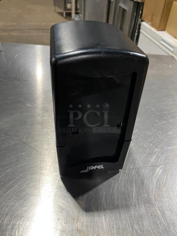 Jofel black tabletop tall-fold napkin dispenser, new condition, branded logo on front, ideal for commercial use.
