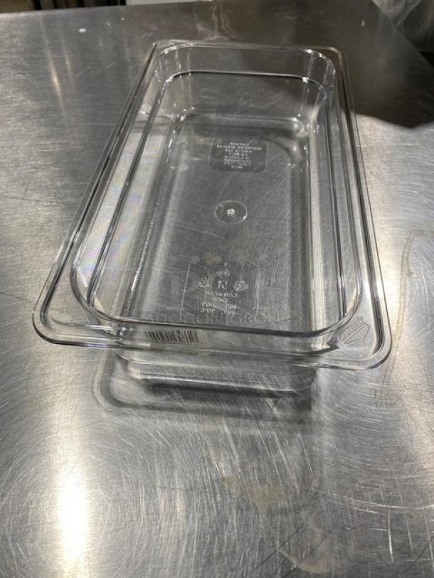 NEW Cambro Camwear Series clear polycarbonate 1/3 size 2" deep food pan, model 32CW135, shown on a metal surface.