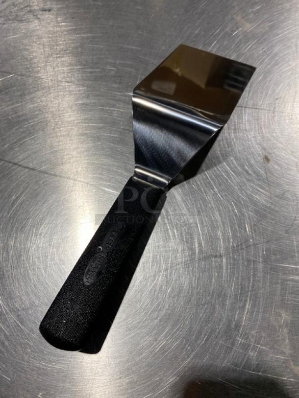 Dexter Russell Sani-Safe stainless steel hamburger turner, model S2864, with 4"x3" blade and black grip handle. New condition.