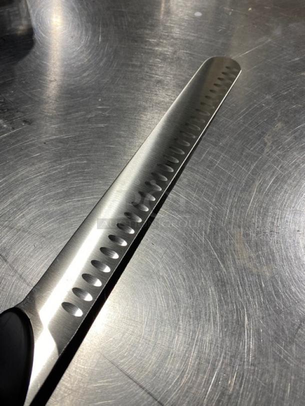 Dexter Russell DuoGlide stainless steel slicing knife with black grip handle, new condition, unique blade design for easy carving.