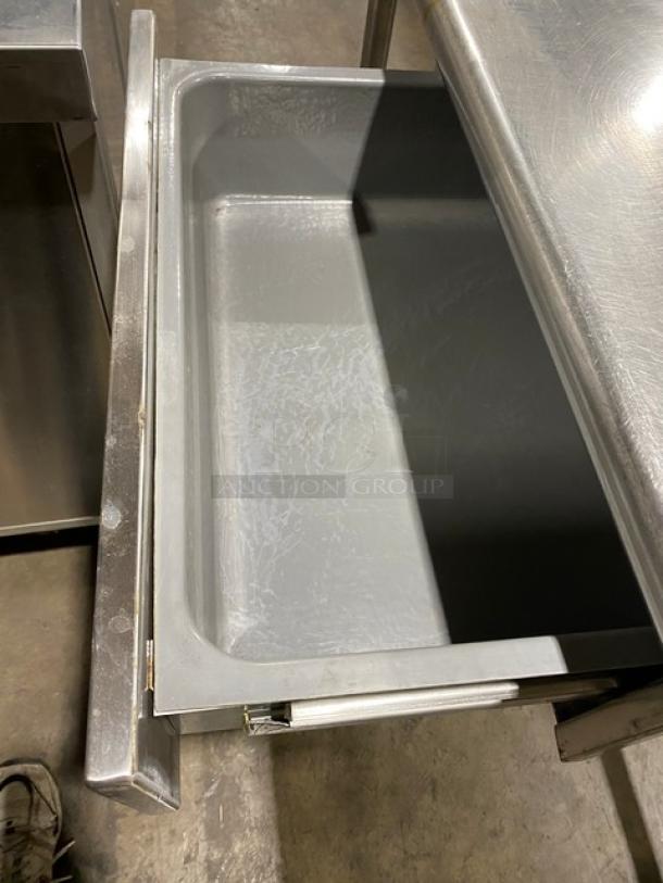 Commercial stainless steel prep table with open base, right-side sink, pull-out drawer, and faucet, on sturdy legs.