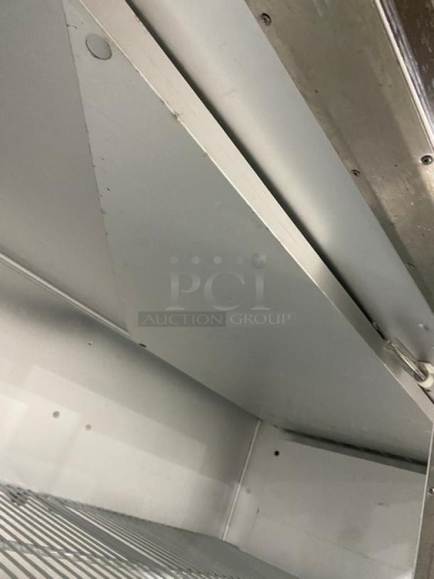 Traulsen G22010 commercial stainless steel refrigerator interior with poly coated wire racks, shown on casters.