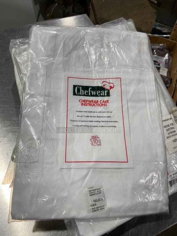 NEW Chefwear white cotton bistro apron, model 162040, with wide tie and pocket. In packaging with care instructions visible.