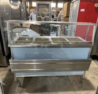 Atlas Metal 4-well stainless steel steamtable with sneeze guard, folding tray slide, and casters. Model WIH-D&M-4, 208V, 1-phase.