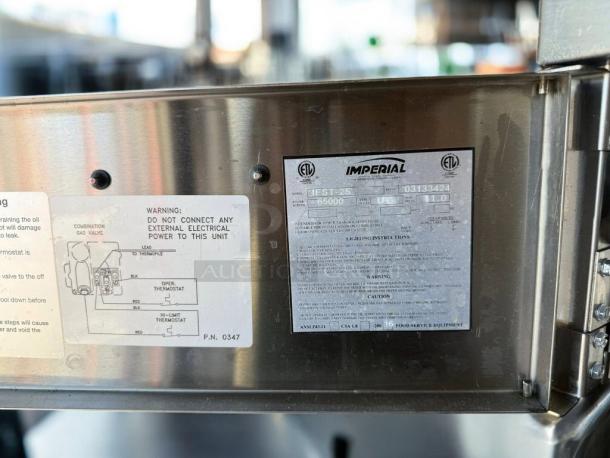 Imperial IEST-25 gas steam table label showing model, 65,000 BTU, and safety instructions on stainless steel.