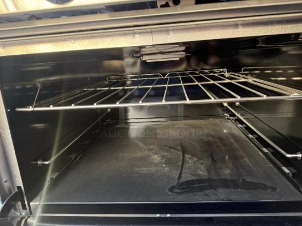 Interior of a Southbend 10-burner gas range oven, pristine condition, featuring a clean rack and floor. Fully tested and working.