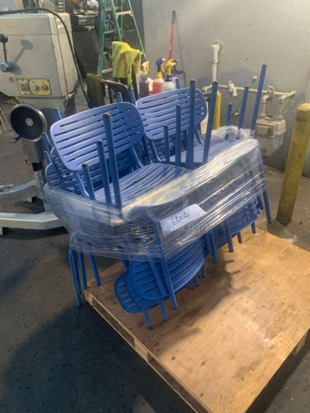 Set of blue metal stackable café chairs, pristine condition, wrapped for inspection. Ready to use. Rustic warehouse setting.