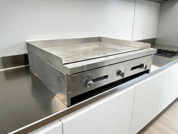 Stratus SMG36 36-Inch Gas Griddle in great condition, tested and working, on stainless steel counter, two control knobs.