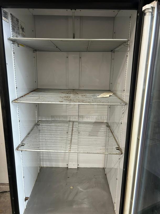 True GDM-26-HC~TSL01 glass door merchandiser, 30", in excellent condition. Features three adjustable wire shelves and visible interior labels.