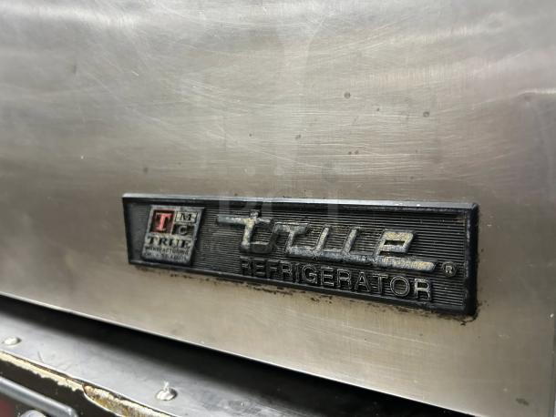 True TUC-27-HC-LP undercounter refrigerator, stainless steel finish, excellent condition, model badge visible.