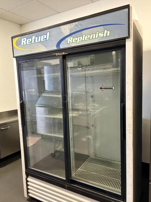 True GDM-45-HC-LD glass door merchandiser, black, two sliding doors, tested working condition, "Refuel Replenish" signage.