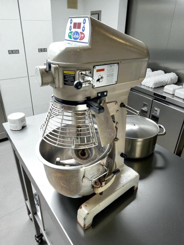 Globe SP20 20 qt planetary mixer on bench, great condition, 1/2 hp, 115v. Control panel and safety cage visible.