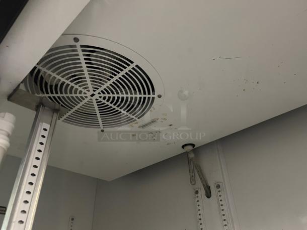 Interior view of a True GDM-45-HC-LD merchandiser. Visible fan and shelving brackets. Some marks present on the inside surface.